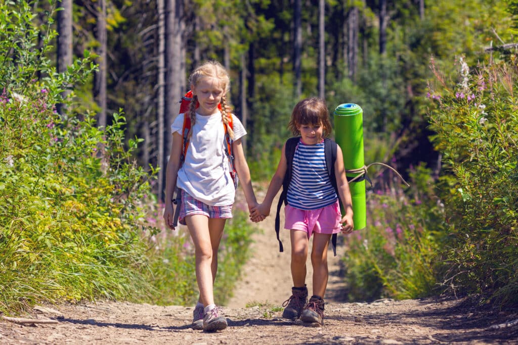 Deux jeunes filles marchent en se tenant la main dans la nature