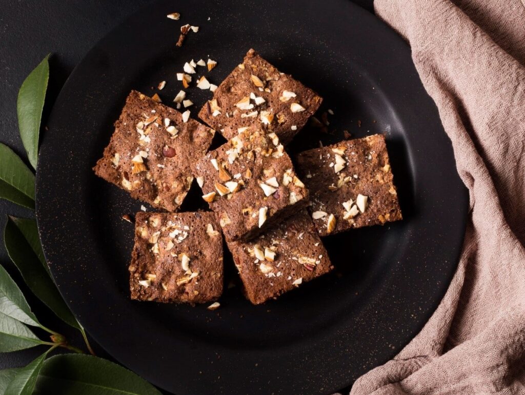 Parts de brownie aux noix dans une assiette noire.