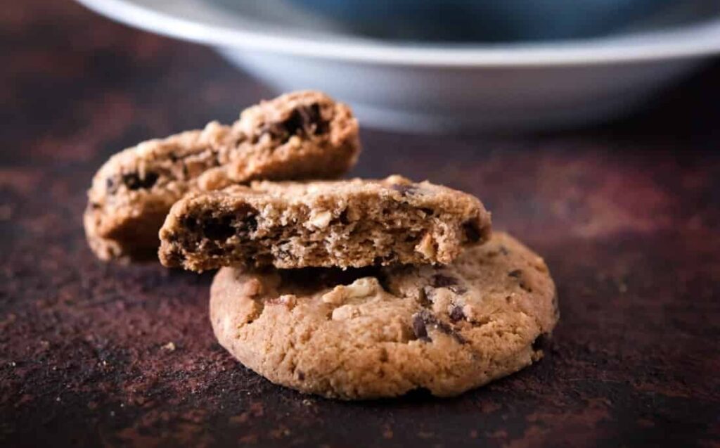 3 Cookies noix et pépites de chocolat au lait sur une table.