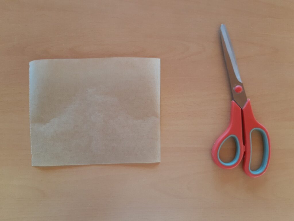 Feuille de papier cuisson avec paire de ciseau rouge.