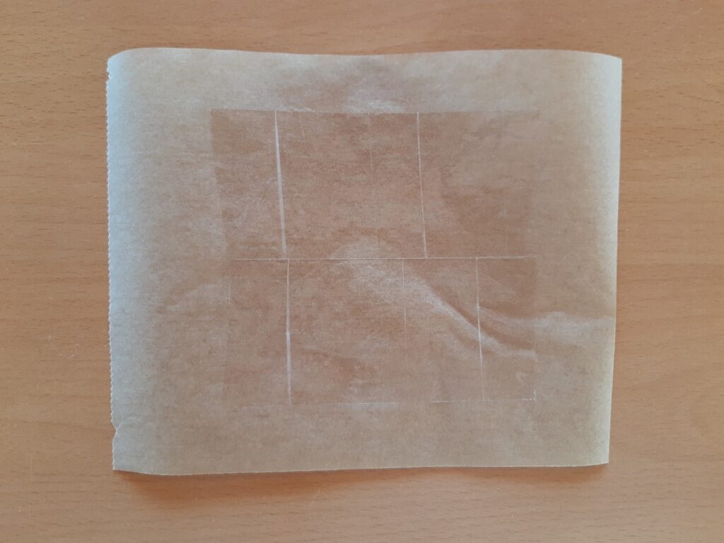 Plusieurs bouts de scotchs posés sur une feuille de papier cuisson.
