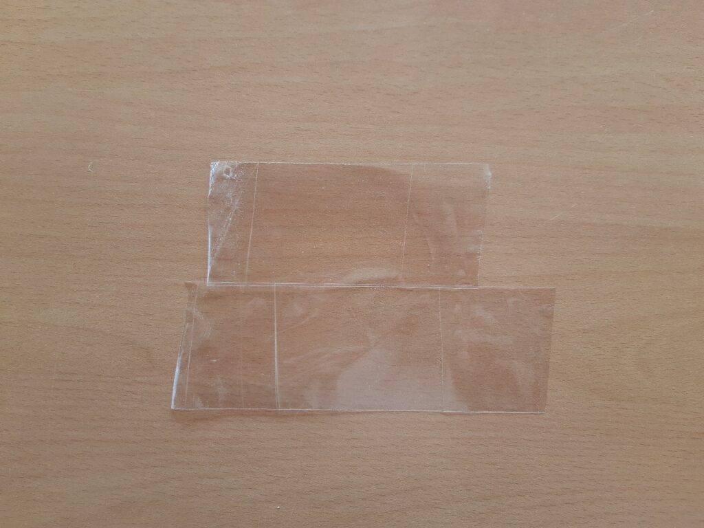 Deux bouts de scotch posé sur une table en bois face collante face au plafond.