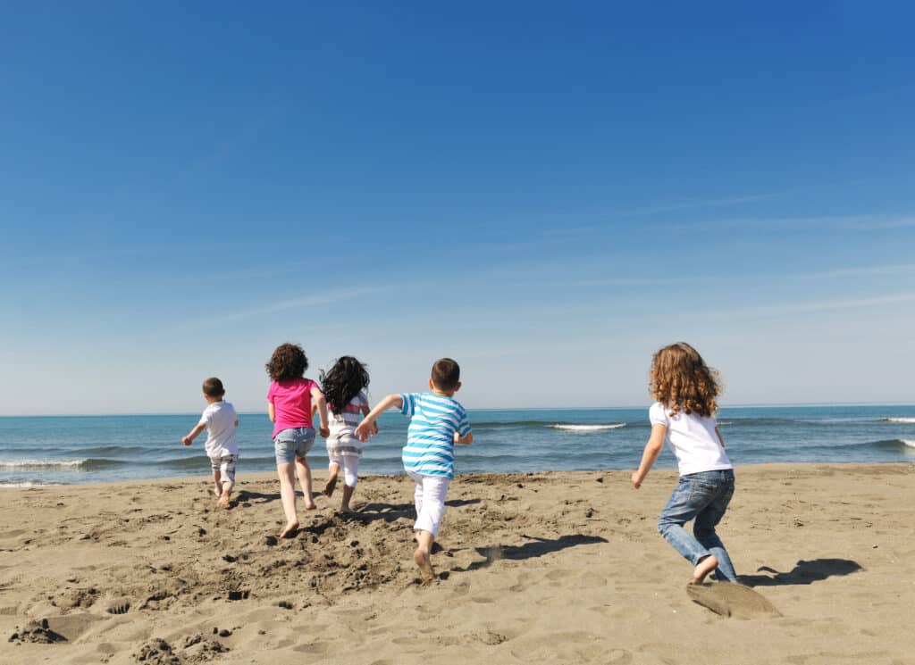 Groupe d'enfants qui courent sur la plage.