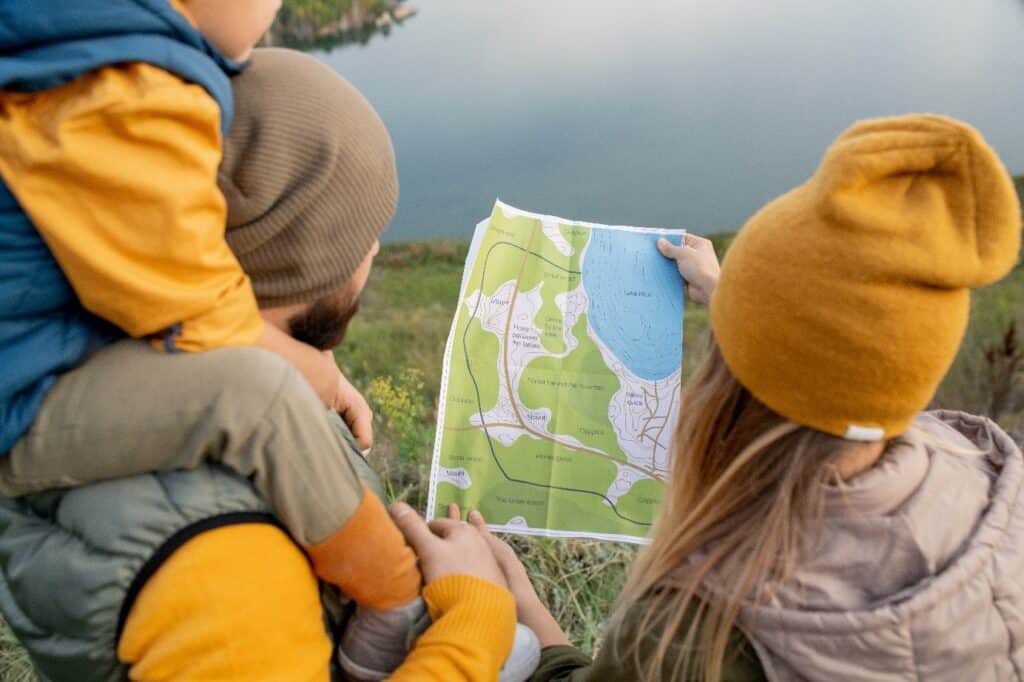 Lire une carte en famille devant un lac en basse saison.