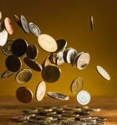 Pièces de monnaie qui tombent sur une table.