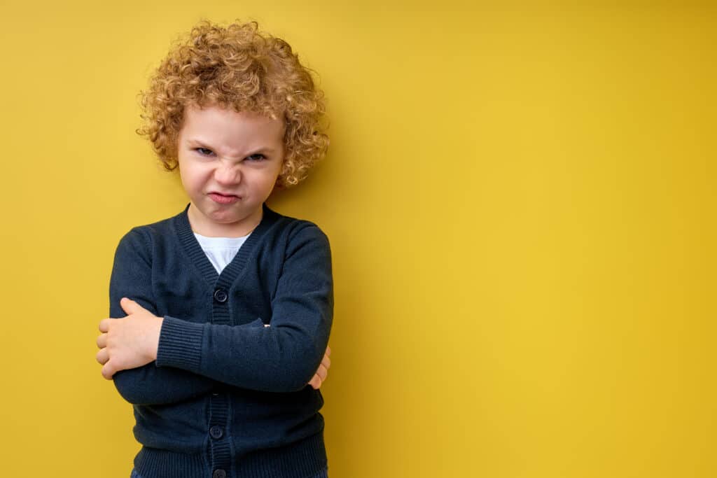Enfant en colère, les bras croisés