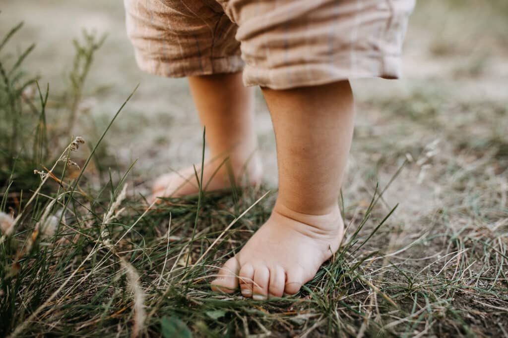 Enfant qui marche pieds nus dans l'herbe