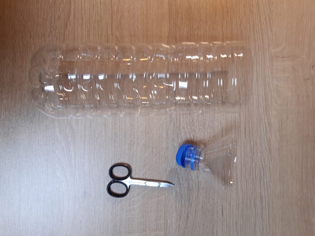 Bouteille d'eau en plastique coupée avec ciseau.