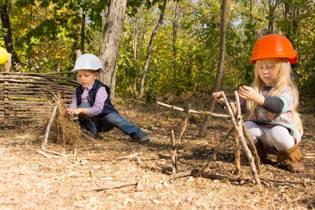Deux enfants qui construisent des cabanes