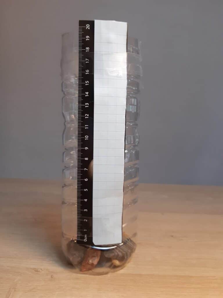 Pluviomètre bouteille en plastique avec échelle.